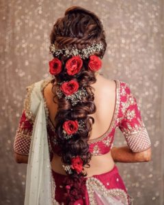 Beads and red roses on the messy curls and braids.